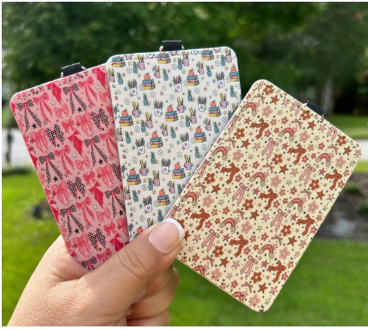 Three finished patterned ID badge holders shown outdoors